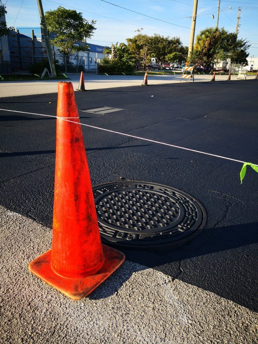 New sealcoated asphalt parking lot in Miami Beach. Road cone blocking customers from parking while the sealcoat dries